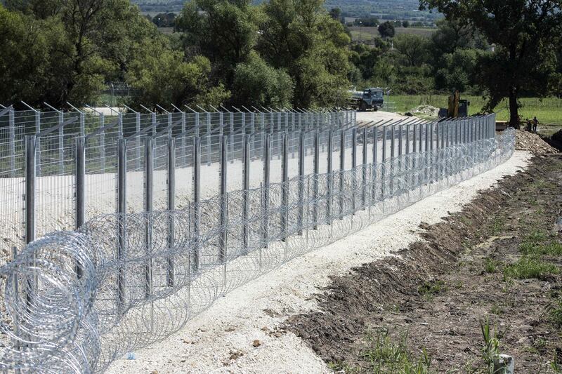 Construction workers work on a fence on the Serbian side at the border with North Macedonia near the northern village of Tabanovce, on August 22, 2020.
 Serbia's government has refused to comment on the construction of a fence near its border with North Macedonia, a common crossing point for migrants traversing the Balkan region. The barrier is being erected on Serbia's southern frontier, close to an official border crossing and a migrant camp on North Macedonia's side, according to an AFP photographer. 
 / AFP / Robert ATANASOVSKI
