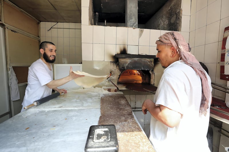 ABU DHABI , UNITED ARAB EMIRATES, September 9 – 2018 :- Zanudin ( left ) making bread at the Shalqar Bakery which is at one of the old building in the Tourist Club area in Abu Dhabi. ( Pawan Singh / The National )  For News. Story by Anna/ John
