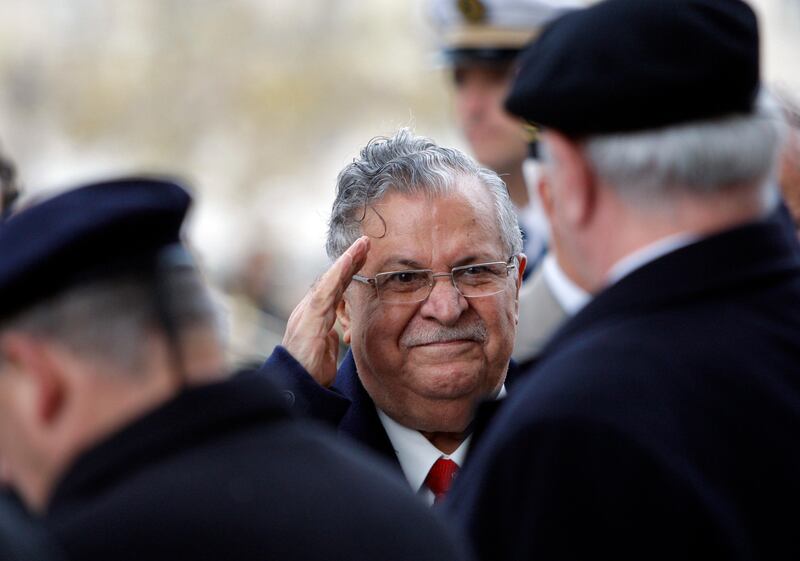 FILE - In this Nov. 17, 2009 file photo, then Iraqi President Jalal Talabani, center, salutes unidentified war veterans at the Tomb of the Unknown soldier under the Arc de Triomphe, in Paris, during his first state visit to France. Talabani, a lifelong fighter for Iraqâ€™s Kurds who rose to become the countryâ€™s president, presenting himself as a unifying father figure to temper the potentially explosive hatreds among Kurds, Shiites and Sunnis has died in a Berlin hospital at the age of 83. (AP Photo/Christophe Ena, Pool)