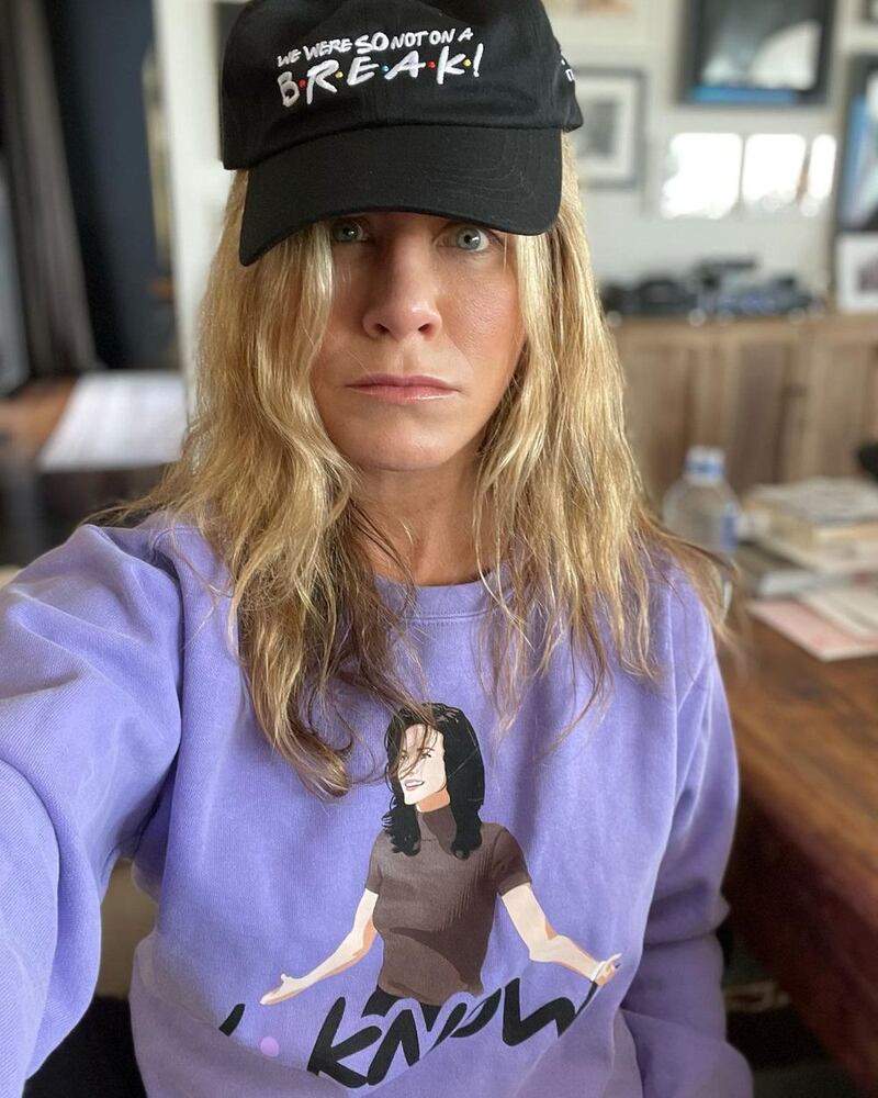 Jennifer Aniston, who played Rachel in 'Friends', wears a 'I know' hoodie and 'We were so not on a break' hat from the limited edition Cast Collection of merchandise
