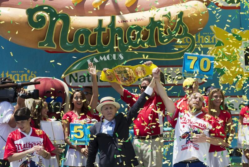 Joey Chestnut, right, is declared Nathan’s Famous Fourth of July International Hot Dog Eating Contest men’s competition winner. Mary Altaffer / AP Photo