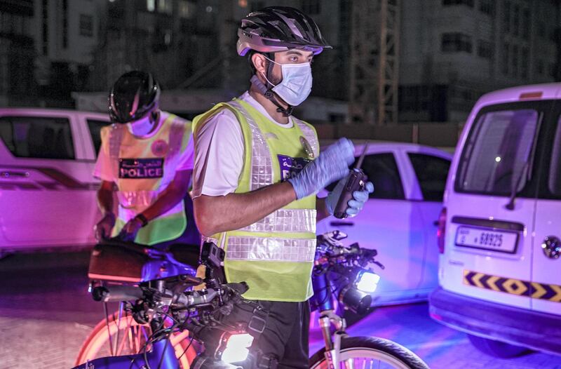 Abu Dhabi, United Arab Emirates, May 11, 2020.   Abu Dhabi Police bicycle patrol do night operations around the Mussaffah area to warn or catch curfew violators in the residential areas.  -- Police officer Hamdan Al Nuaimi reminds curfew violators for strict compliance during night operations.Victor Besa / The NationalSection:  NAReporter:  Haneen Dajani