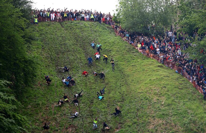 People compete in the annual Cooper's Hill Cheese Rolling competition in Brockworth, Britain. Reuters