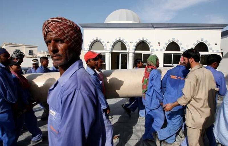 DUBAI, UNITED ARAB EMIRATES Ð May 26, 2011: Workers carrying the carpet roll at the Al Farooq mosque in Al Safa area in Dubai. (Pawan Singh / The National) For News. Story by James
