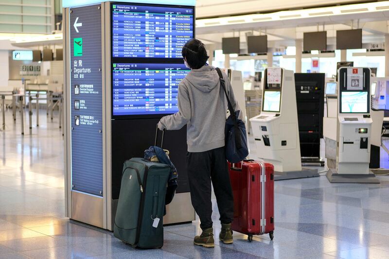 A traveller looks at a flight information board at Haneda International Airport in Tokyo. Japan's Transport Ministry had issued a request to international airlines to stop taking new reservations for flights into the country. AFP