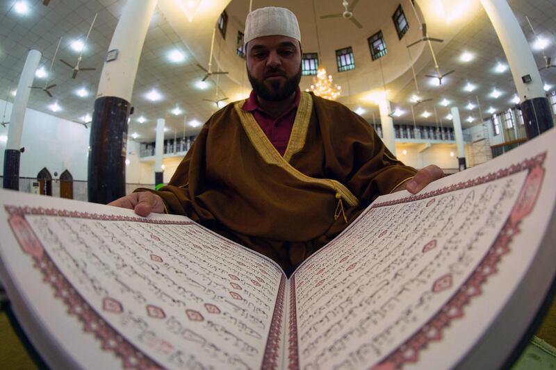 The muezzin of the grand mosque of Basra, closed down due to the coronavirus pandemic, reads the Quran.  AFP
