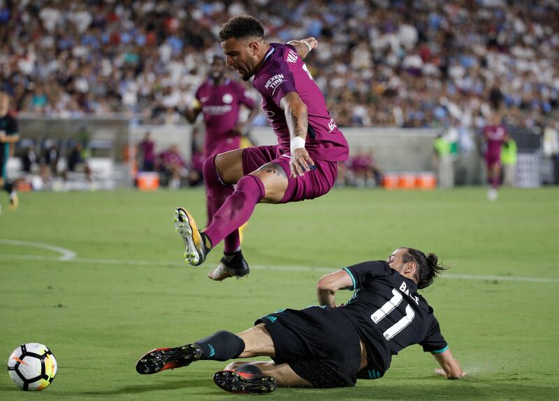 Manchester City's Kyle Walker, top, avoids a tackle from Real Madrid's Gareth Bale. Jae C Hong / AP Photo