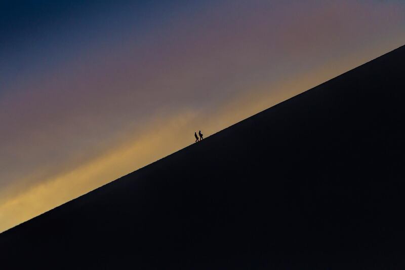 People climb a dune near Crescent Lake in Dunhuang, Gansu Province, China. Aleksander Plavevski/EPA