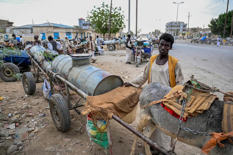People queue for water from tanks drawn by donkeys in Port Sudan. AFP