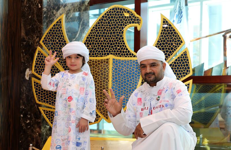 Three-year-old Khalifa Abdullatif Hajee Jaafar Mohamed and Muhammad Asim Muhammad Nasim Durrani, a Dubai Customs employee, model kandoras covered in Expo pavilion stamps. All Photos Pawan Singh / The National.