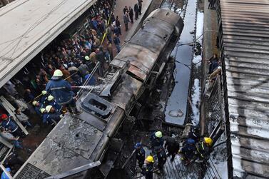 Fire fighters and onlookers gather at the scene of a train crash at Cairo's main railway station. AFP