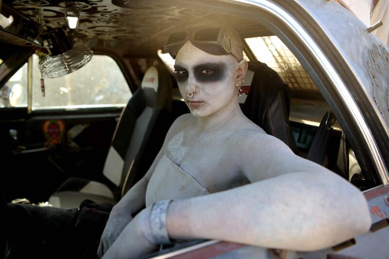 A woman poses for pictures in her car during Wasteland Weekend festival at the Mojave desert in Edwards, California. AFP