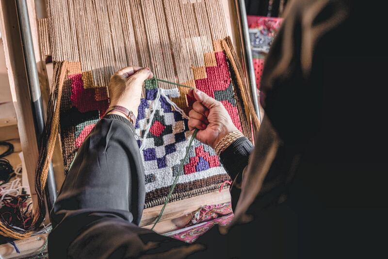 Khalid Harthi, Saudi Arabia: A woman is shown practicing the traditional art of embroidery as she knits and weaves her art into a frame to be displayed in the Okaz Souq near Ta’if.