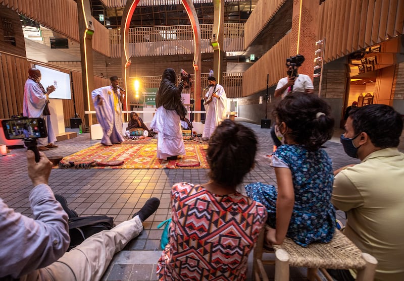 Dancers and musicians entertain a crowd at the halqa, a space where traditionally street artists show their skills, in the Morocco pavilion. Victor Besa / The National