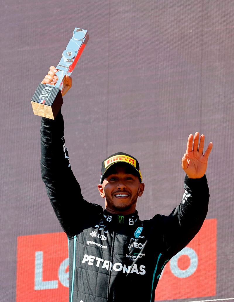 Mercedes' Lewis Hamilton celebrates with a trophy on the podium after finishing second. Reuters