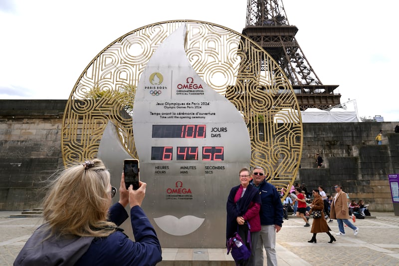 Members of the public take photos in front of the countdown clock for the Paris 2024 Olympics at Port de la Bourfonnais near the Eiffel Tower, Paris. PA