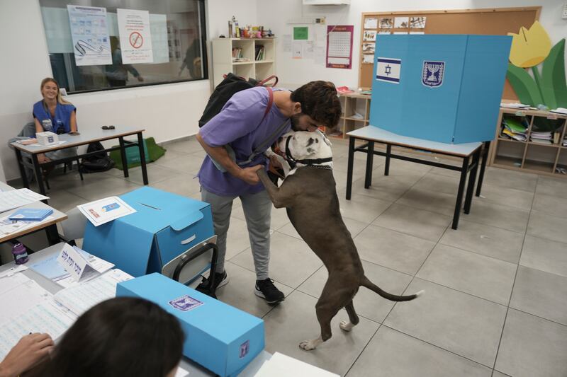 A man kisses his dog after casting his ballot in Tel Aviv during the Israeli elections. AP 