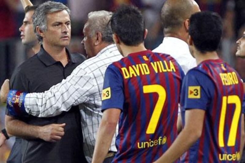 Jose Mourinho, left, gets involved in the fracas between Barcelona and Real Madrid players and staff last night.