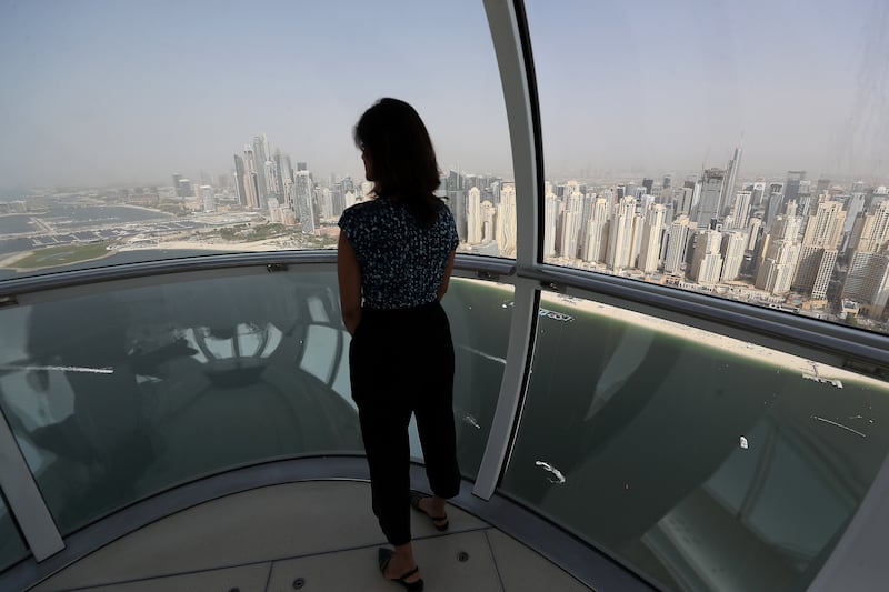 A visitor takes in the skyline from a cabin in Ain Dubai. Pawan Singh / The National