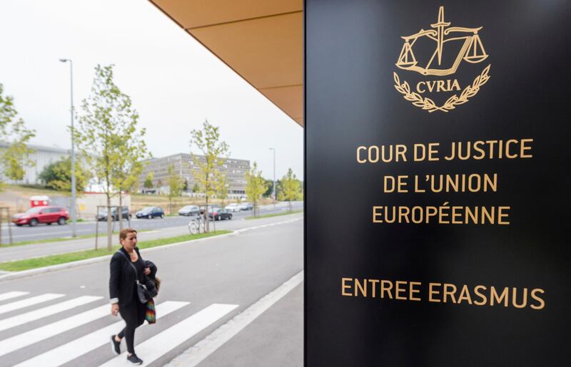 FILE - In this Oct. 5, 2015 file photo, a man walks by the European Court of Justice in Luxembourg. The European Court of Justice on Wednesday, Sept. 6, 2017, rejected efforts by Hungary and Slovakia to stay out of a European Union scheme to relocate refugees. (AP Photo/Geert Vanden Wijngaert, File)