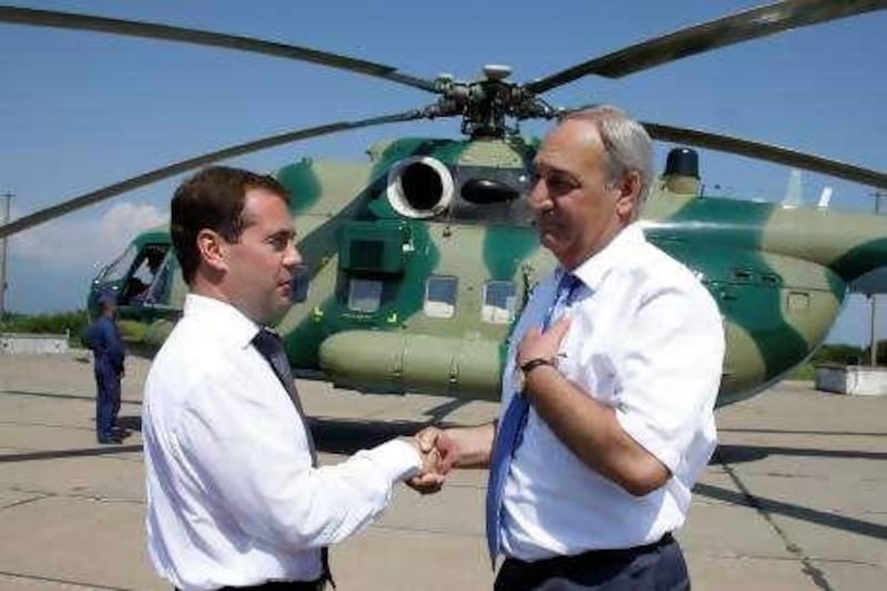 Russian President Dmitry Medvedev, left, and Abkhazia's separatist President Sergei Bagapsh, 2nd left, speak  during their visit to the Russian military base at the key Black Sea port of Gudauta in the Georgian breakaway region of Abkhazia, Sunday, Aug. 8, 2010. Medvedev pledged Sunday to provide further support to breakaway Georgian regions on the anniversary of the Russian-Georgian war. He arrived in Abkhazia to hold talks with the Kremlin-friendly separatist government. (AP Photo/RIA-Novosti, Dmitry Astakhov, Presidential Press Service)