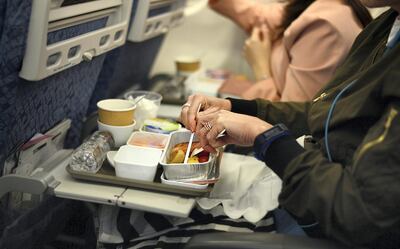 Image of passenger enjoying in-flight breakfast on board of an international flight.