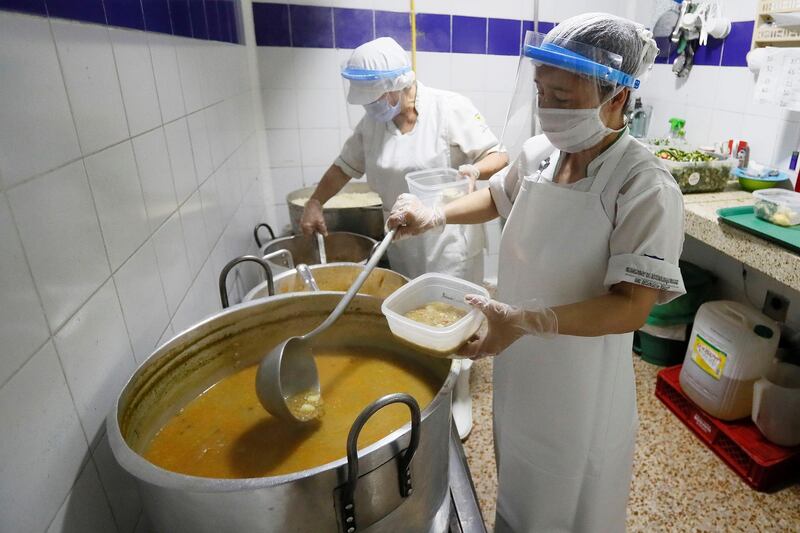 Workers prepare food to distribute in a community dining room in Bogota, Colombia. EPA