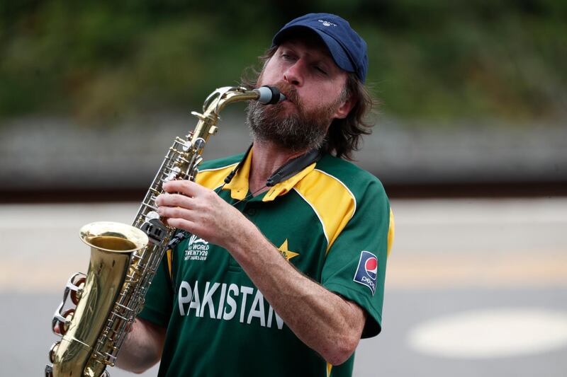 A Pakistani fan plays saxophone next to the ground at Old Trafford. AP