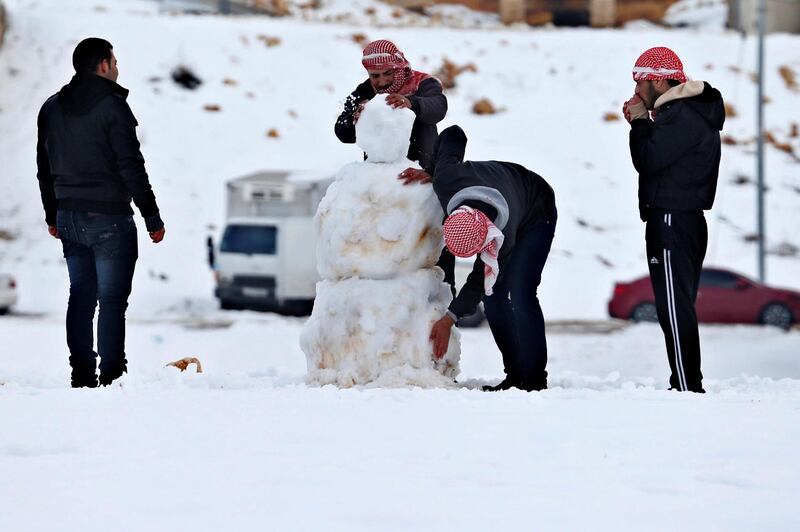 People play with snow after a heavy snowstorm in Amman January 11, 2015. A storm buffeted the Middle East with blizzards, rain and strong winds, keeping people at home across much of the region and raising concerns for Syrian refugees facing freezing temperatures in flimsy shelters. The storm is forecast to last several days, threatening further disruption in Lebanon, Syria, Turkey, Jordan, Israel, the West Bank and the Gaza Strip, which have all been affected. REUTERS/Muhammad Hamed (JORDAN - Tags: DISASTER ENVIRONMENT)