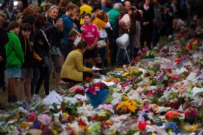 People pay their respects at a memorial site at the Botanical garden in Christchurch on March 18, 2019, three days after a shooting incident at two mosques in the city that claimed the lives of 50 Muslim worshippers. New Zealand will tighten gun laws in the wake of its worst modern-day massacre, the government said on March 18, as it emerged that the white supremacist accused of carrying out the killings at two mosques will represent himself in court. / AFP / Marty MELVILLE
