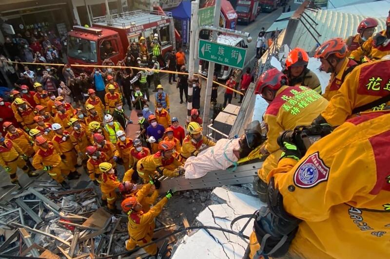 A survivor is pulled to safety from the wreckage. AFP