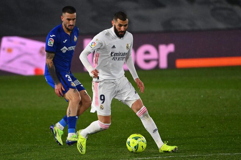 Real Madrid's Karim Benzema closely watched by Getafe defender Erick Cabaco. AFP