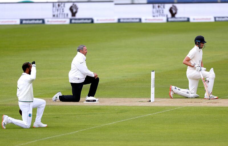 England's Dom Sibley, right, takes a knee in support of the Black Lives Matter movement during day one of the Test Series at the Ageas Bowl in Southampton. PA