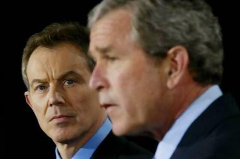 British Prime Minister Tony Blair listens as United States President George W. Bush makes an announcement on the Iraq invasion on March 27, 2003.