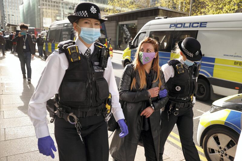 Police officers detain an activist from the Extinction Rebellion, a global environmental movement, during a protest outside HSBC headquarters in Canary Wharf, London, Britain April 22, 2021. REUTERS/John Sibley