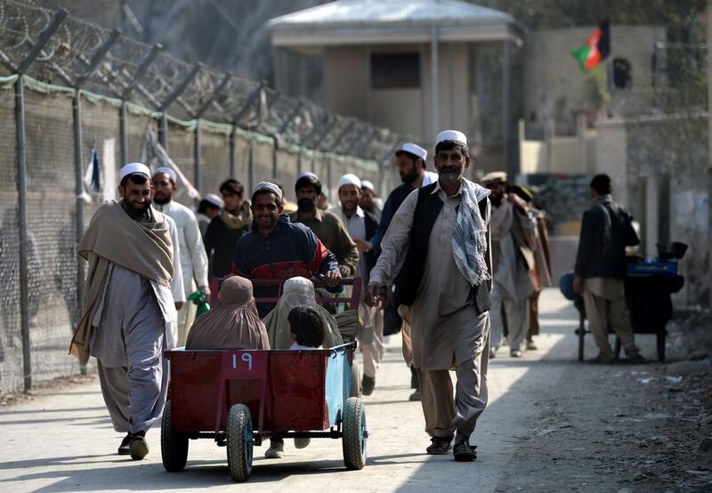 An Afghan pushes a cart carrying his family as they cross the border from Pakistan at Torkham in Nagarhar province. Wakil Kohsar / AFP photo