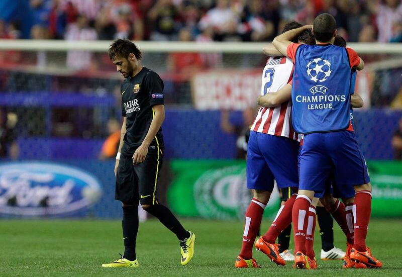 FC Barcelona forward Neymar, left, leaves the pitch as Atletico players celebrate at the end of the Champions League quarter-final on Wednesday. Paul White / AP / April 9, 2014