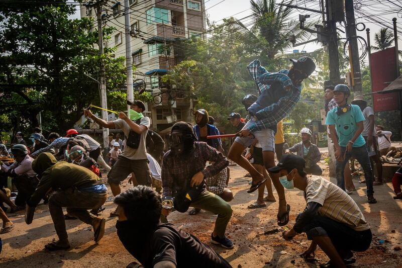 Anti-coup protesters use slingshots and throw stones at approaching security forces on March 28, 2021, in Yangon, Myanmar. Getty Images
