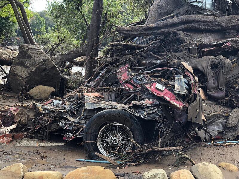 A vehicle wrapped and tangled around a tree by the force of deadly flood waters on Hot Springs Road following heavy rains in Montecito, California. Mike Eliason / Santa Barbara County Fire / EPA