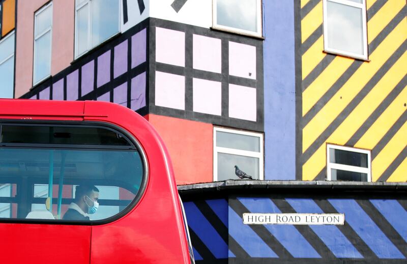 A man wearing a face mask travels on a bus, as it drives past a mural created by artist Camille Walala, amid the spread of the coronavirus disease (Covid-19), in Leyton, London. Reuters