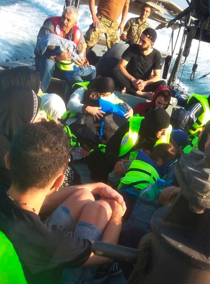 Rescued migrants sit on a Lebanese army boat after their own vessel capsized off the coast of Akkar. AP