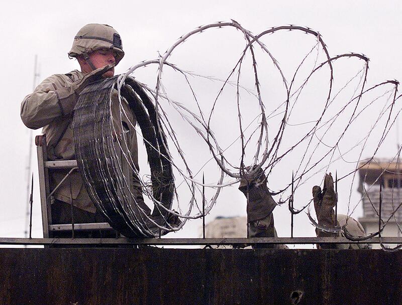 US Marines, seen here placing barbed wire around the US embassy in Kabul on January 11, 2002, are returning to Afghanistan's capital to help embassy workers and Afghans leave the country. AFP