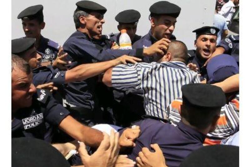 Jordanian police beat a protester during a demonstration demanding reforms and the resignation of the prime minister, in Amman last week. AFP PHOTO/KHALIL MAZRAAWI Khalil Mazraawi / AFP Photo