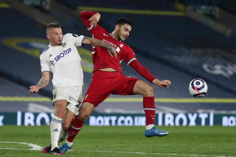 Leeds United's English midfielder Kalvin Phillips (L) challenges Liverpool's Turkish defender Ozan Kabak (R) during the English Premier League football match between Leeds United and Liverpool at Elland Road in Leeds, northern England on April 19, 2021. (Photo by LEE SMITH / POOL / AFP) / RESTRICTED TO EDITORIAL USE. No use with unauthorized audio, video, data, fixture lists, club/league logos or 'live' services. Online in-match use limited to 120 images. An additional 40 images may be used in extra time. No video emulation. Social media in-match use limited to 120 images. An additional 40 images may be used in extra time. No use in betting publications, games or single club/league/player publications. / 