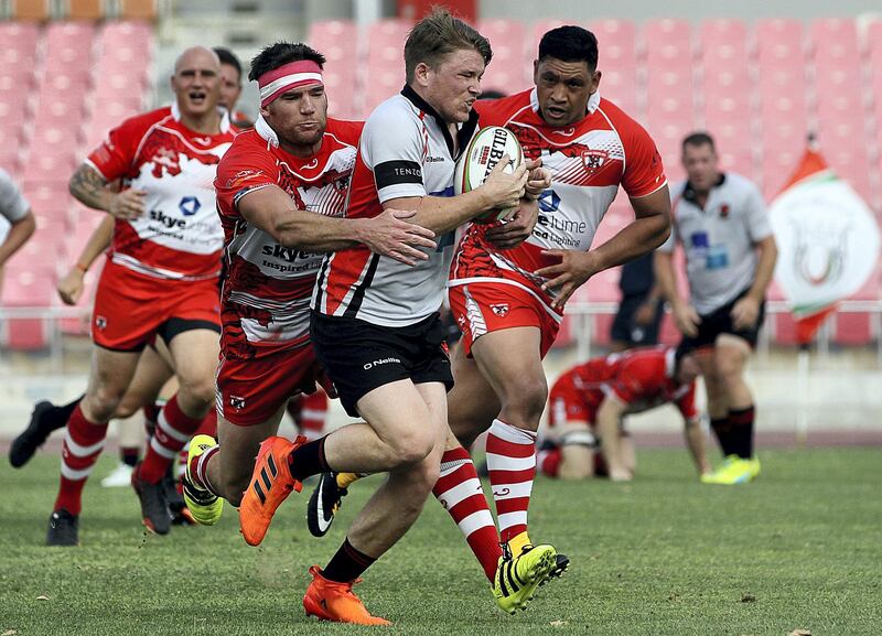 Dubai, April 13, 2018: (L) Peter Kelly makes a tackle for Dubai Tigers ( Red)  during the UAE Conference finals match against Sharjah Wanderers.  at the Rugby Park in Dubai. He scored the winning try in extra time. Satish Kumar for the National / Story by Paul Radley