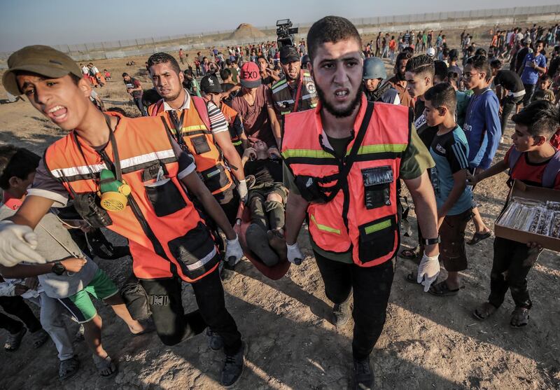 epa07895897 Palestinian medicals carry a wounded young man after Friday protests near the border between Israel and Gaza Strip, eastern Gaza Strip, 04 October 2019. A 28-year old protester was shot dead and more than 51 Palestinian protesters were injured during the protests along the border between Israel and eastern Gaza Strip.  EPA/MOHAMMED SABER