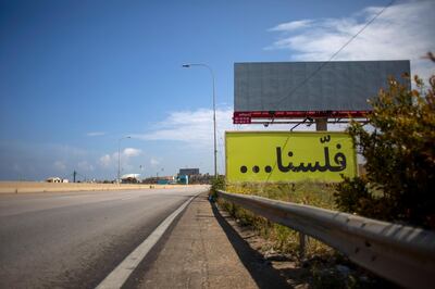 FILE - In this Tuesday, May 5, 2020 file photo, a billboard with Arabic that reads, "We are broke, is displayed on an empty major highway that links the capital Beirut to the northern city of Tripoli, Lebanon. Lebanon's government agreed Tuesday, July 21, 2020  to hire a New York-based company to conduct a forensic audit of the country's central bank accounts to determine how massive amounts of money were spent in the nation plagued by corruption. (AP Photo/Hassan Ammar, File)