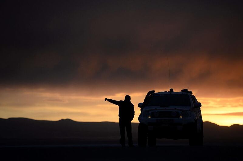 Dakar Rally director Etienne Lavigne gestures during the sunset in Uyuni last week while he and staff scout locations for the 2015 race. Franck Fie / AFP / September 18, 2014