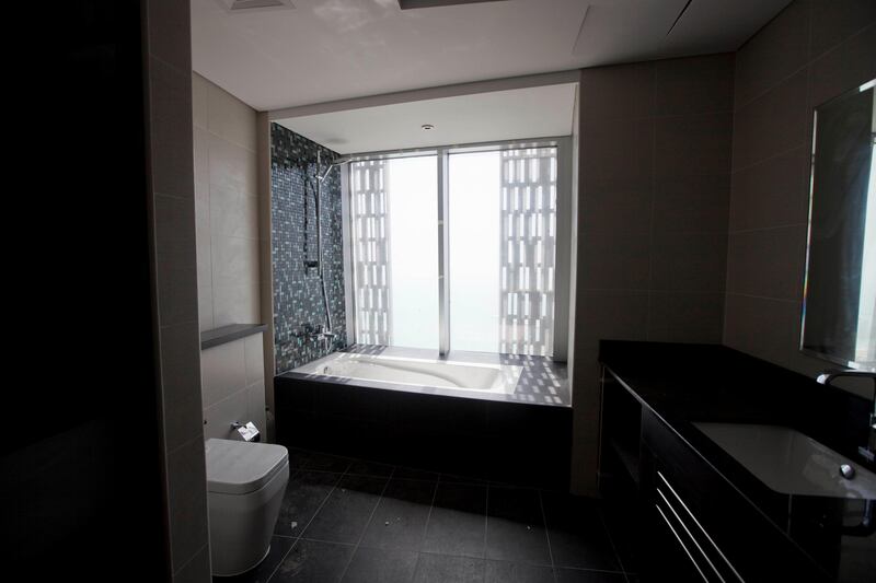 Dubai, United Arab Emirates - June 11 2013 - The interior of a 57th floor four bedroom duplex apartment at the Cayan Tower in the Dubai Marina. Seen here is the bathtub with a view of the Palm Jumeirah (Razan Alzayani / The National)