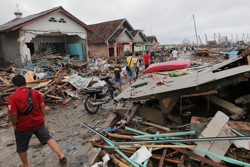 People inspect damaged in Sumur. AP Photo